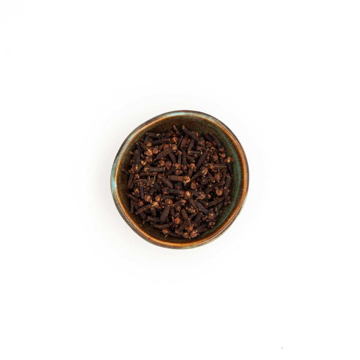 Bol de clous de girofle Épices Moralès vu du dessus, clous entiers bruns pour marinades, vin chaud et bouillons.