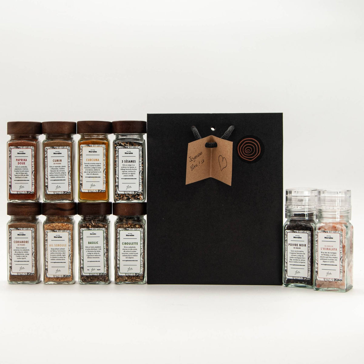 Coffret Les 10 Essentielles Épices Moralès ouvert, ses dix fioles en verre alignées devant l'étui noir.