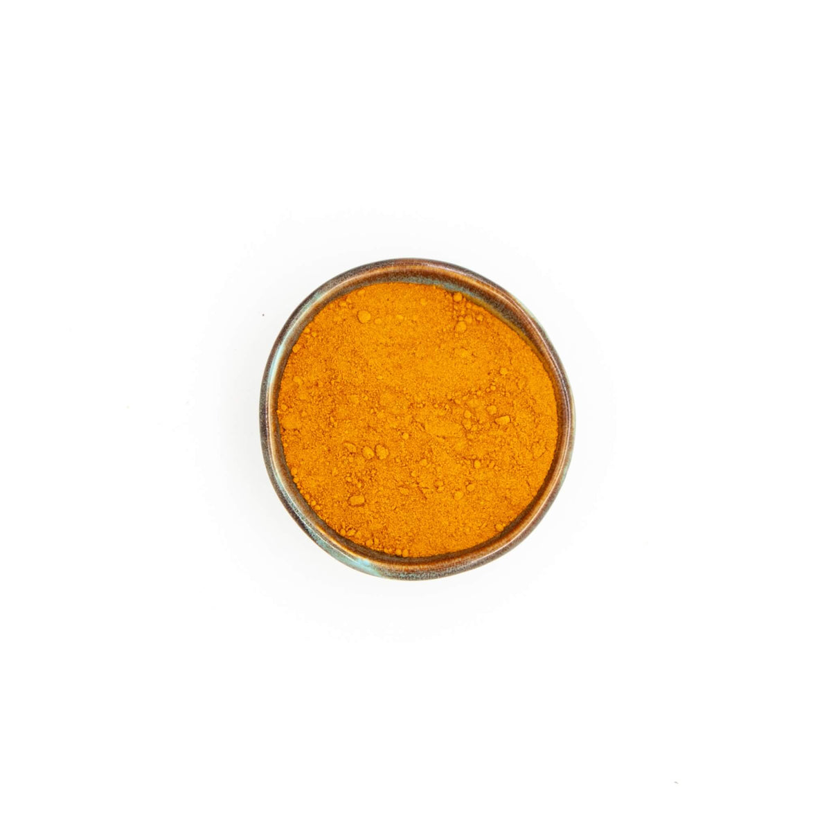 Bol de curcuma en poudre Épices Moralès vu du dessus, poudre jaune orangé pour riz, currys et laits dorés.