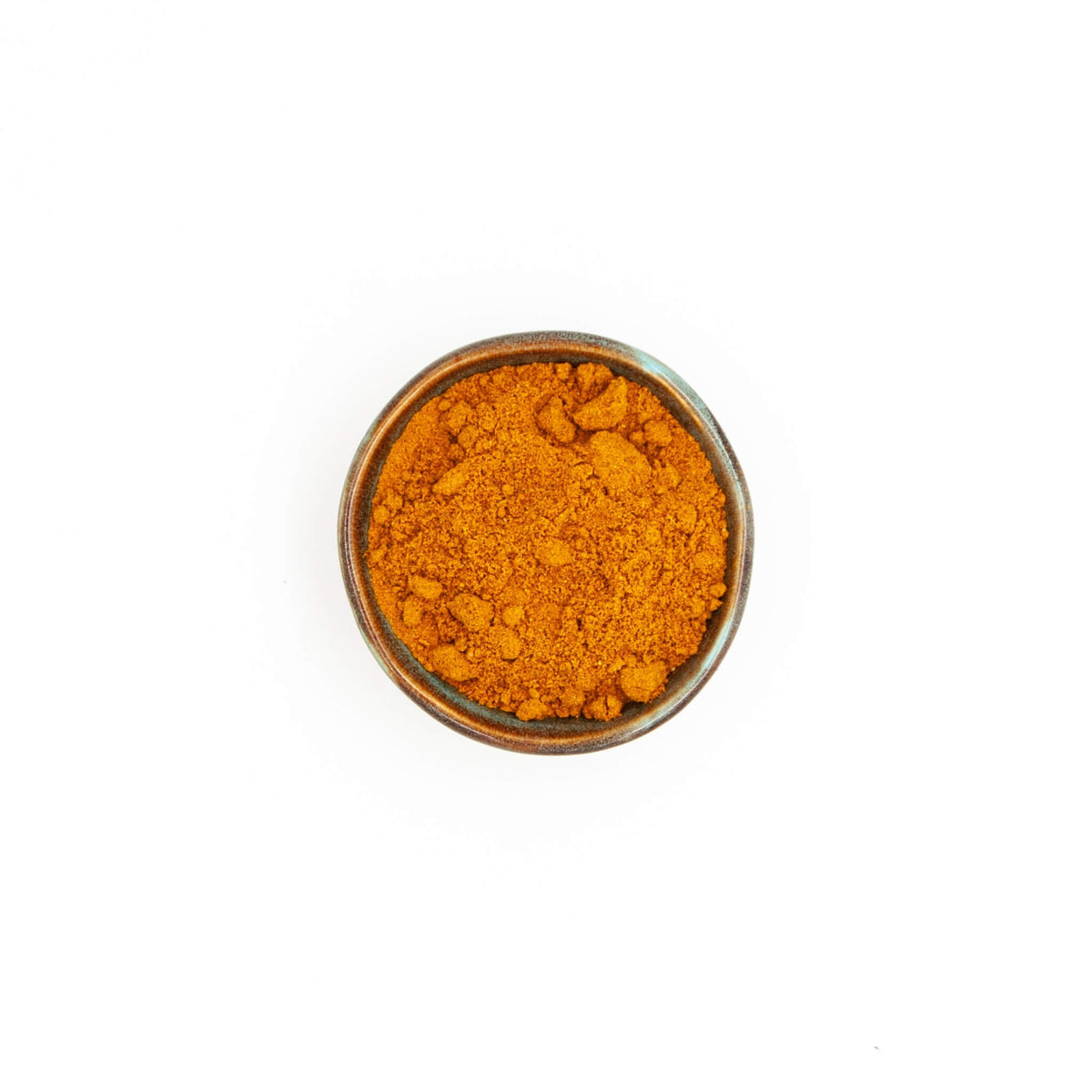 Bol de curry Madras Épices Moralès vu du dessus, mélange orangé aux notes relevées pour volailles et légumes.