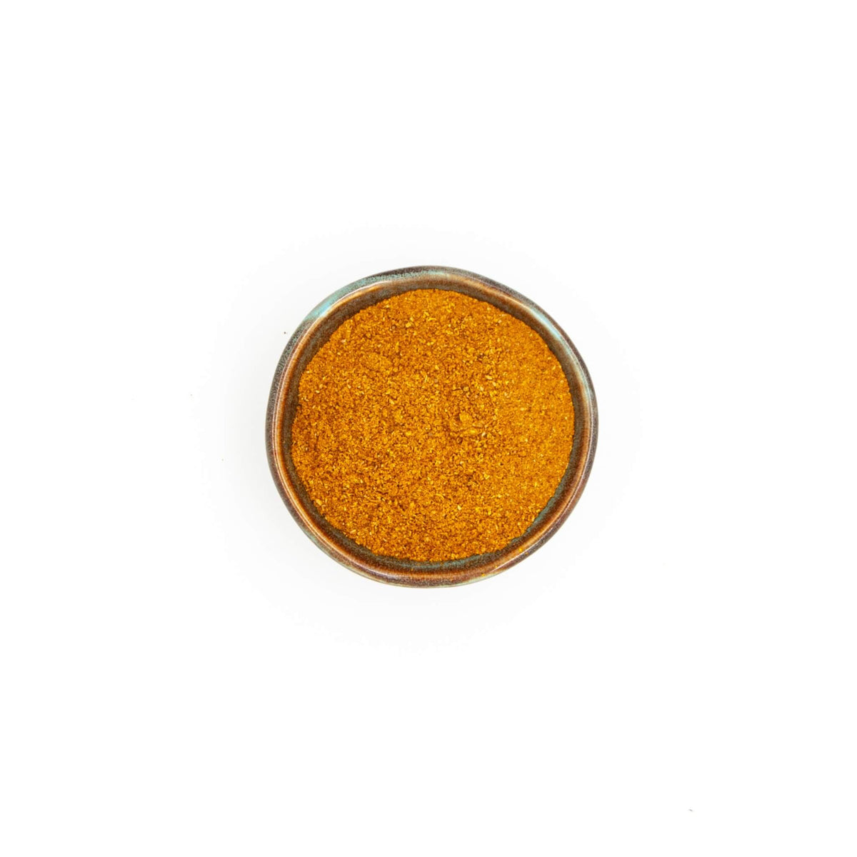 Bol du mélange pour poulet Épices Moralès vu du dessus, poudre orangée pour volailles rôties et marinades.
