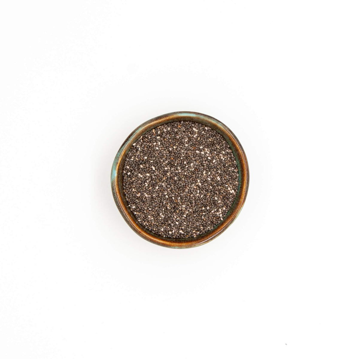 Bol de graines de chia Épices Moralès vu du dessus, petites graines sombres pour puddings, yaourts et pains.