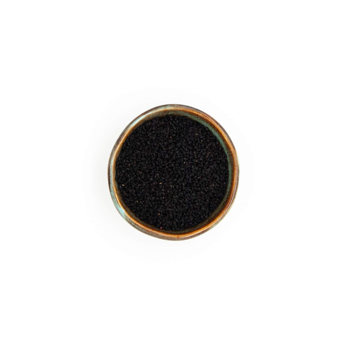 Bol de graines de nigelle Épices Moralès vu du dessus, graines noires anguleuses pour pains, naans et fromages.