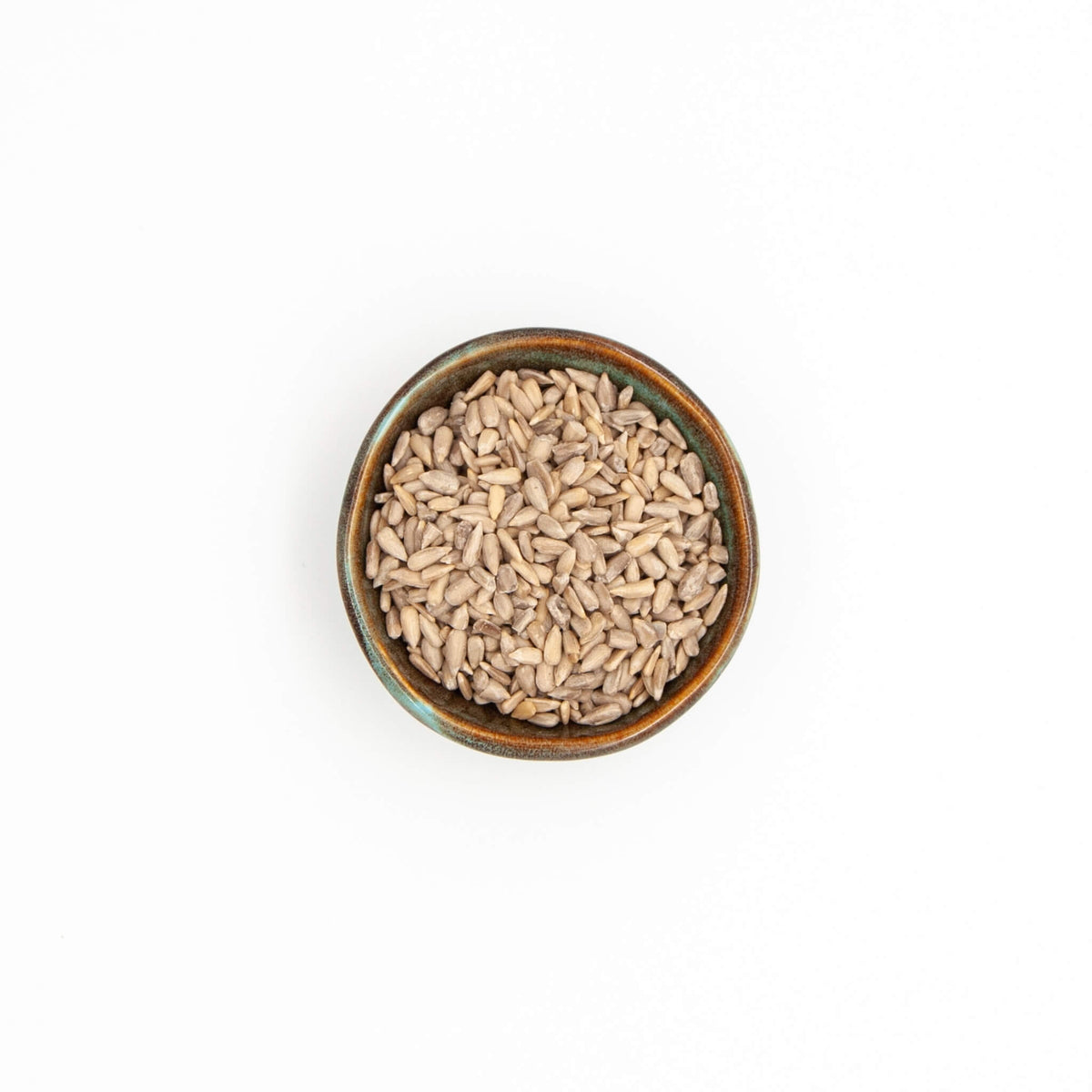 Bol de graines de tournesol Épices Moralès vu du dessus, amandes décortiquées à parsemer sur salades et pains.