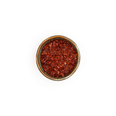Bol de piment Ñora Épices Moralès vu du dessus, flocons rouges aux notes de poivron pour riz et ragoûts.