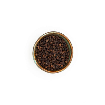 Bol de poivre noir en grains Épices Moralès vu du dessus, grains entiers pour moulin, bouillons et marinades.